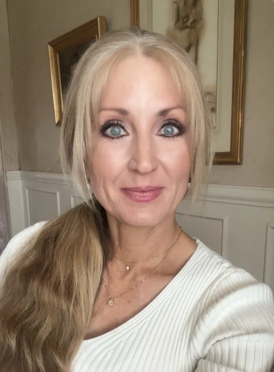 Carol Whitaker, life coach for women, smiling in a white sweater
